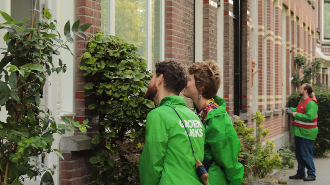 Foto van mensen in GroenLinksjasjes die langs de deuren gaan