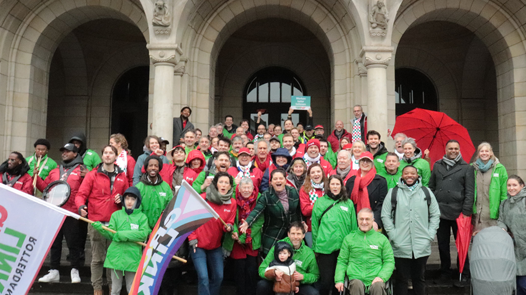 Groep vrolijke GroenLinksers en PvdA'ers voor het Rotterdamse stadhuis