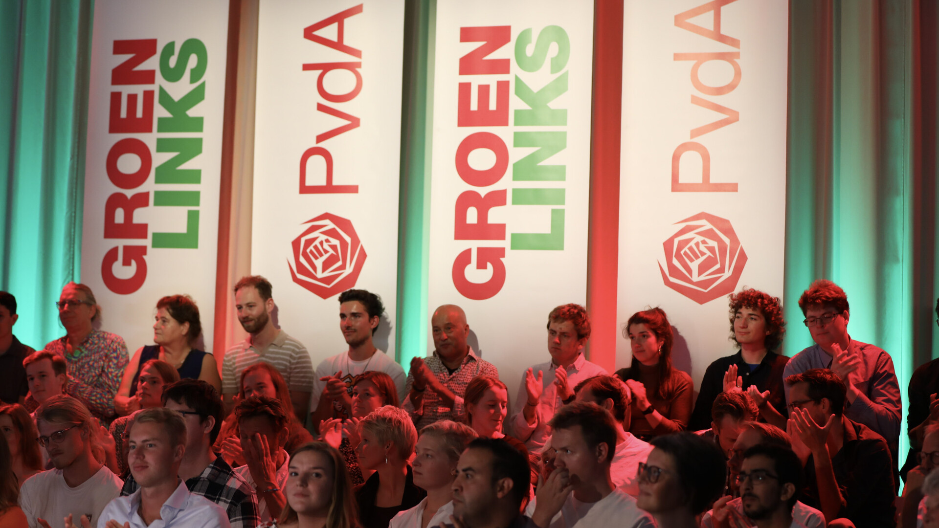 Banieren met de logo's van GroenLinks en PvdA met daarvoor een publiek